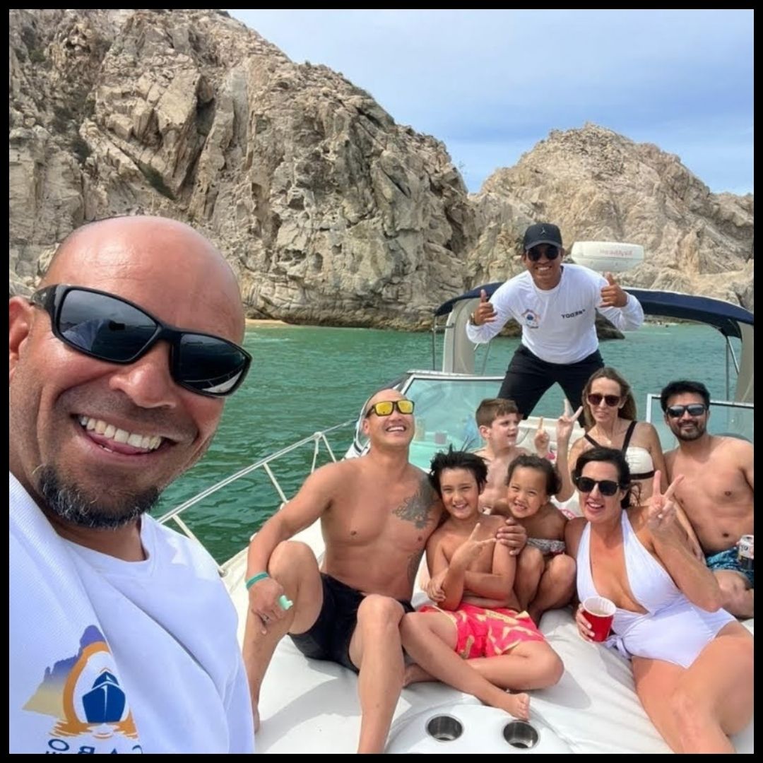 large group smiling for photo on yacht with crew